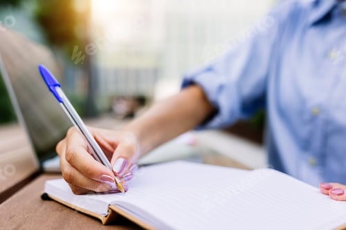 Preview: Closeup businesswoman hand holding pen writing on notebook outside