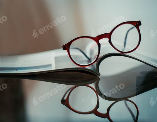 Preview: Red Glasses Resting on an Open Magazine