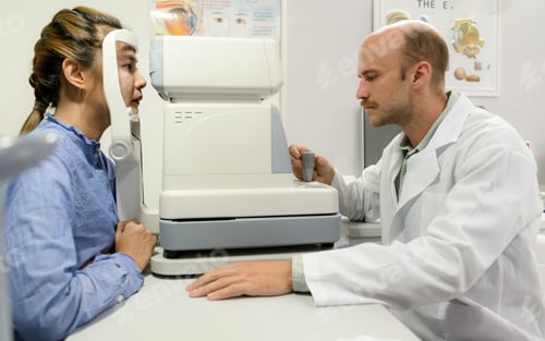 Preview: A young woman checks her eyes with an optometrist.