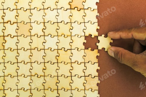 Preview: hand holding the last puzzle to be solved or finished. Compliting final task.