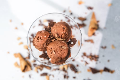 Preview: Top view of chocolate ice cream scoops in glass with waffle and chocolate pieces