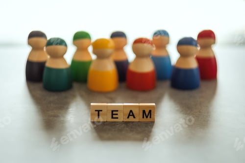 Preview: TEAM word on wooden blocks with a group of people in the background