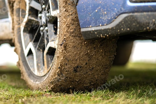 Preview: Close up of dirty car wheel with rubber tire covered with yellow mud