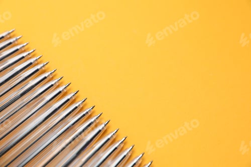 Preview: Many ballpoint pens on orange background, above view. Space for text