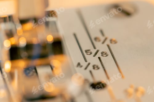 Preview: close-up in a sewing workshop a metal part from a sewing machine with numbers