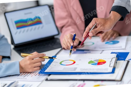 Preview: A group of people are looking at a table with graphs and charts
