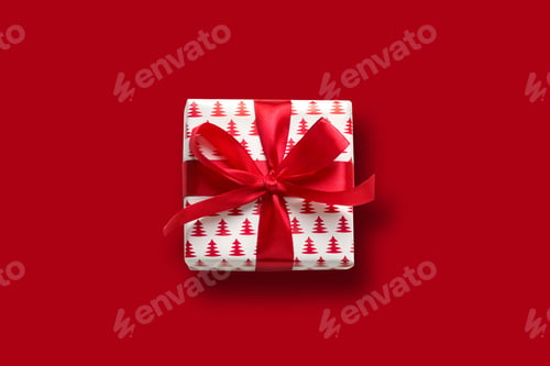 Preview: Christmas gift with red bow on white. Xmas. Happy. New Year. Flat lay style.