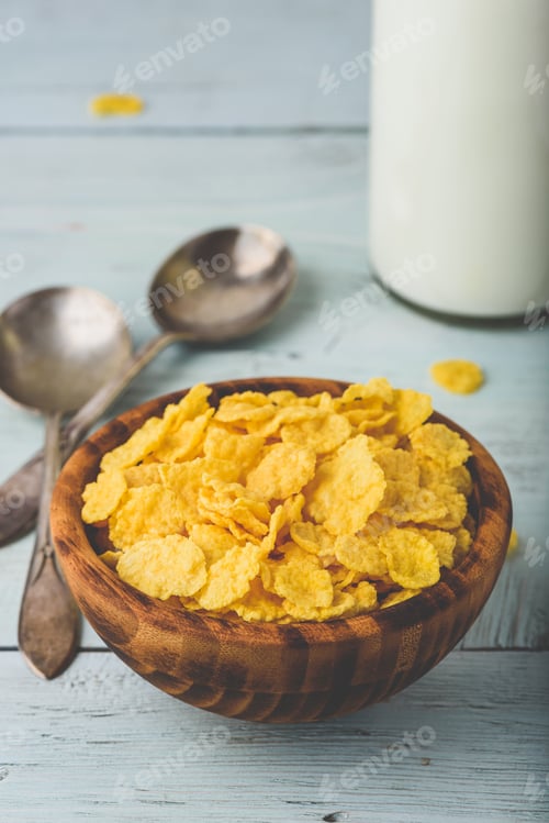 Preview: Bowl of corn flakes with spoons and bottle of milk