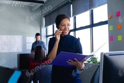 Preview: African American woman working with headset phone in office