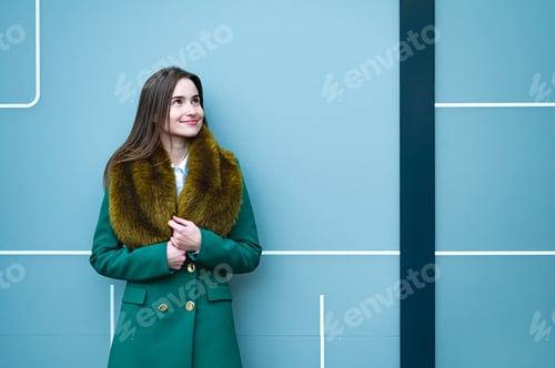 Preview: closeup portrait of an elegantly dressed business woman near a blue wall of a modern office building