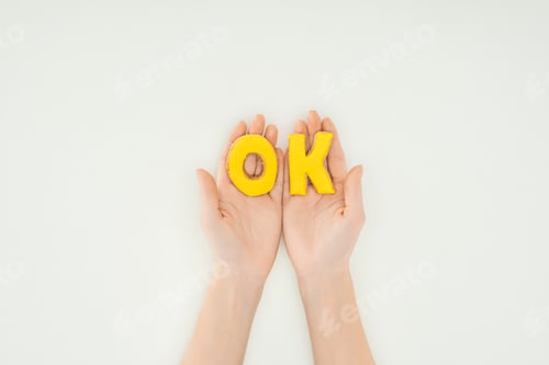 Preview: cropped person holding ok word in cookies isolated on white background