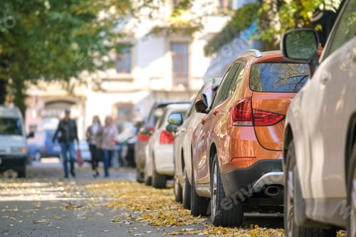 Preview: City traffic with many cars parked in line on street side
