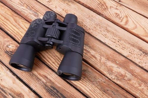 Preview: Black binoculars on a wooden surface