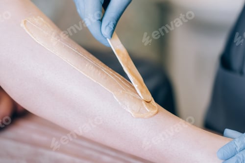 Preview: The specialist depilates the hair with wax on the leg