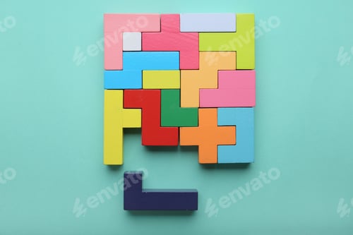 Preview: Multicolored puzzle, hand and cubes on a mint background