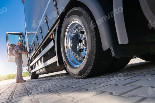Preview: Trucker Inspecting Semi-Trailer Tire