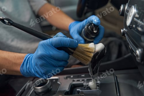 Preview: Worker in gloves cleans salon with brush