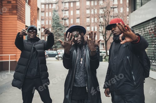 Preview: three young men posing outdoor looking camera gesturing with hands
