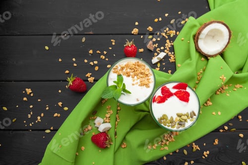 Preview: Home-made Yoghurt with granola, fruit and coconut top view on wooden background