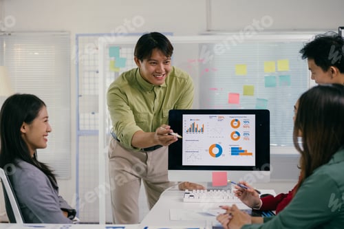 Preview: Asian business team analyzing charts on computer in office meeting