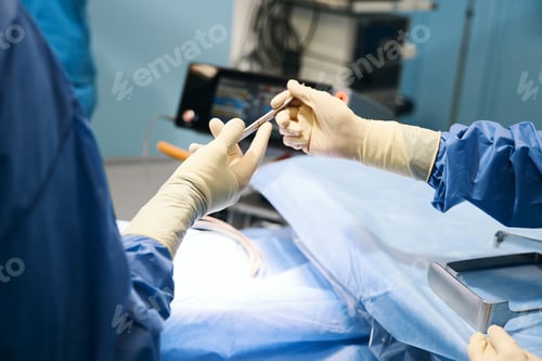 Preview: Medic in operating room passing surgical instrument to colleague assistant