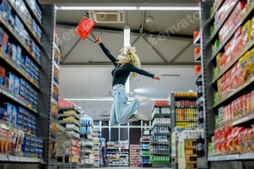 Preview: Woman in a supermarket jumping and wearing protective face mask while grocery shopping