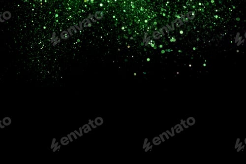 Preview: Beautiful, sparkling green glitter pouring down from above on a dark background