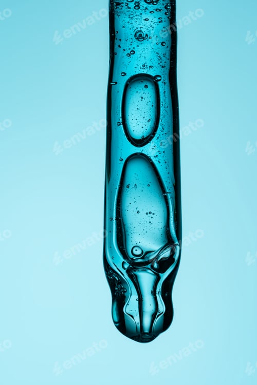 Preview: Pipette with serum, gel, oil or other cosmetic product with falling drop. Macro closeup
