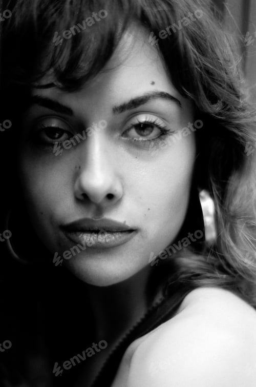 Preview: Confident woman looking at camera in a monochrome head-shot.