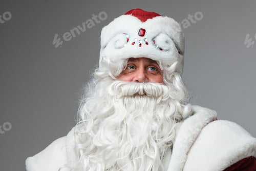 Preview: Mature man in Santa hat with gray beard and moustache, studio portrait, headshot on gray background