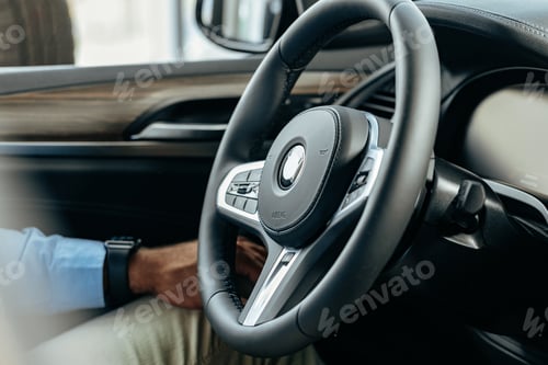 Preview: Male hands holding steering wheel of a car