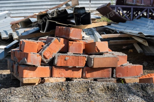 Preview: A pile of old red bricks with the remains of dried mortar. Building material red brick with holes.