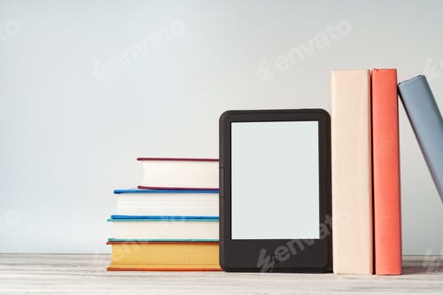 Preview: Digital tablet with a stack of books on gray background