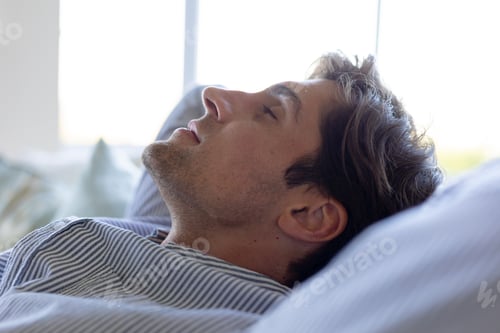 Preview: Young man relaxing on sofa at home