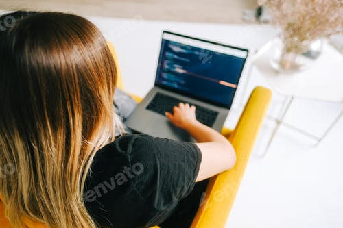 Preview: Young woman mobile developer writes program code on a computer, programmer work.