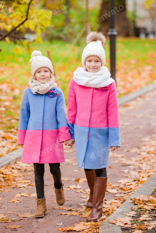 Preview: Little adorable girls outdoors at warm sunny autumn day