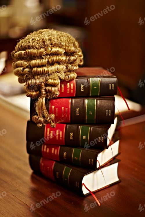 Preview: Knowledge of the law is crucial for a fair trial. Shot of legal books and a wig on top of a table.