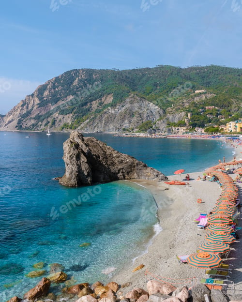 Preview: Pebble beach Monterosso vacation Chairs and umbrellas on the beach of Cinque Terre Italy.