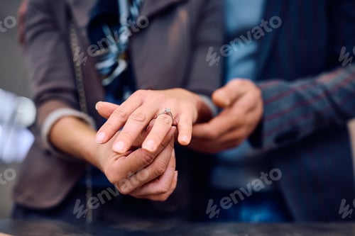 Preview: Close up of woman wearing engagement ring.