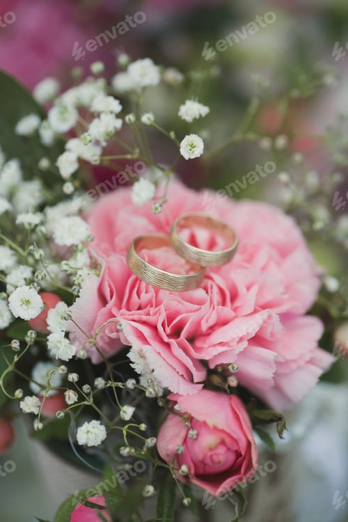 Preview: Gold wedding rings on a bouquet of fresh flowers
