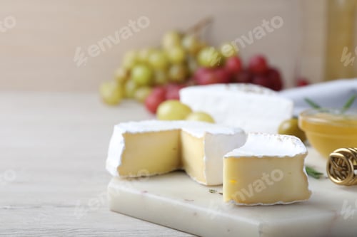 Preview: Tasty brie cheese on white wooden table, space for text