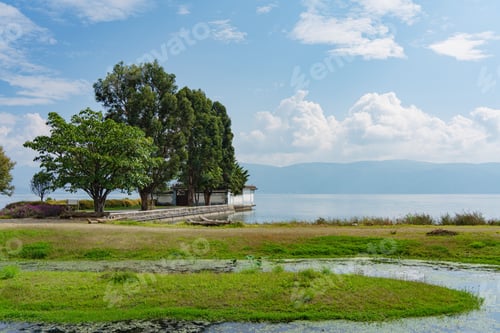 Preview: Scenic lakeside with lush greenery and clear sky