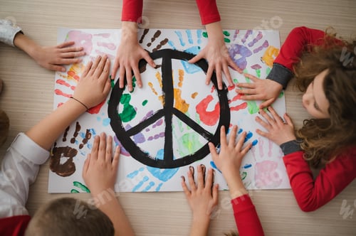Preview: Top view of children making a poster of peace sign at school