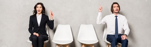 Preview: panoramic shot of happy brunette woman and handsome man gesturing while sitting on chairs