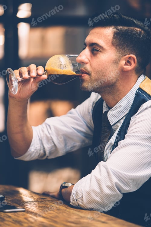 Preview: Handsome man drinking coffee from wine glass