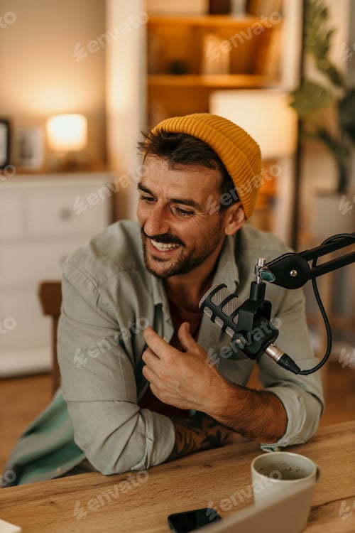 Preview: Content creator recording podcast from home smiling and talking into microphone