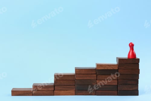 Preview: Red piece on wooden stairs against light blue background. Career promotion concept