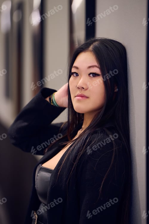 Preview: Portrait of a beautiful young Asian woman in a black coat and boots