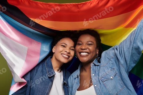 Preview: Loving lesbian couple celebrates pride in stylish denim with vibrant rainbow flag