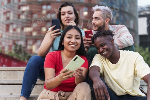 Preview: Latin and African American friends sharing social media content on smart phone